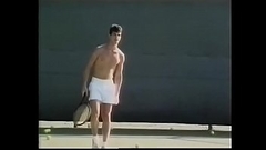 Tennis player likes to loosen his penis stiff muscles after excercises with ball shooter machine and drop his load on his tennis racket Thumb